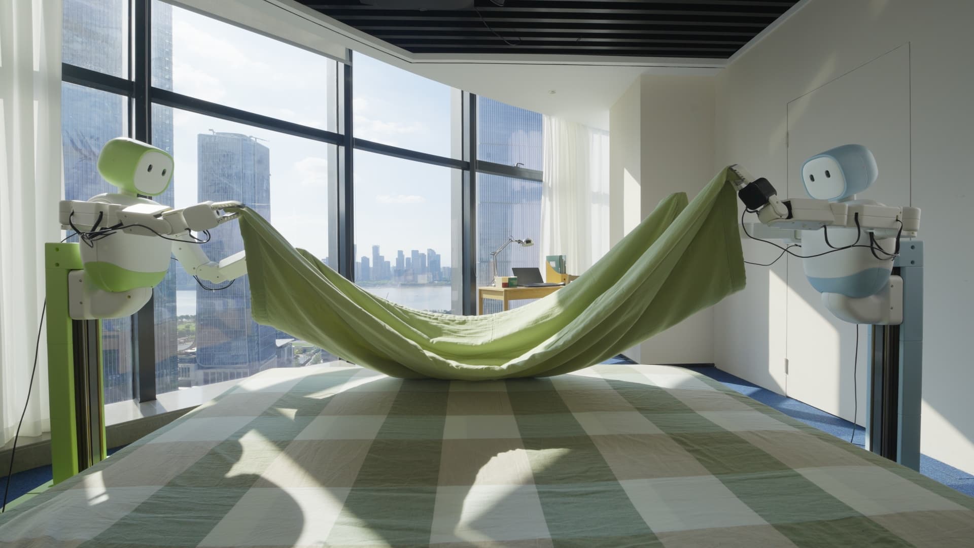 Two Zeno robots lifting a green sheet together in a bright room